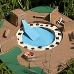 Modellbau: aus Pape gebastelte Landschaft, mit Häusern, Schwimmbecken und Rasen